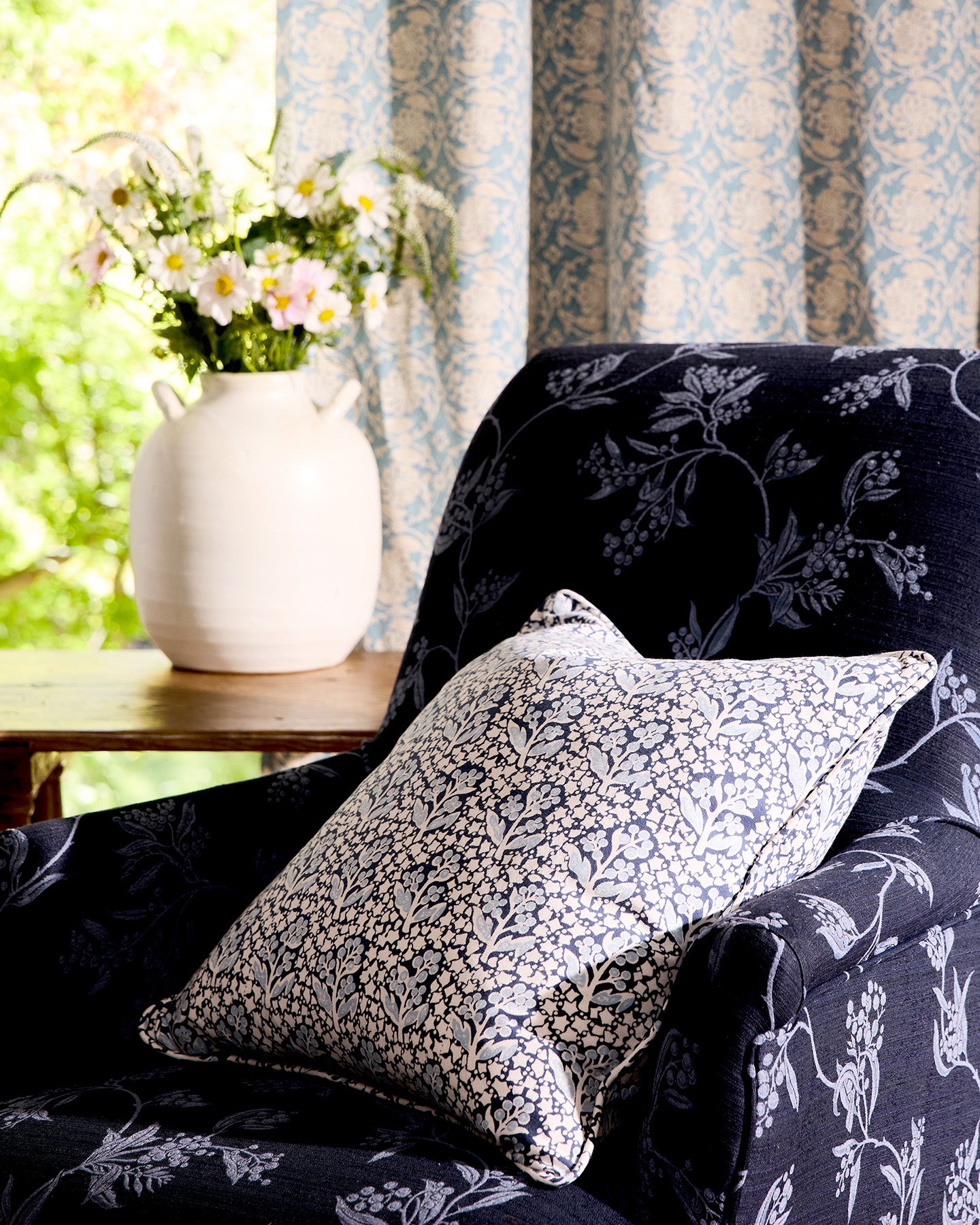 Utopia Goods Acacia Blue Medium Cushion Cover: blue floral patterned cushion on dark upholstered chair with matching curtains
