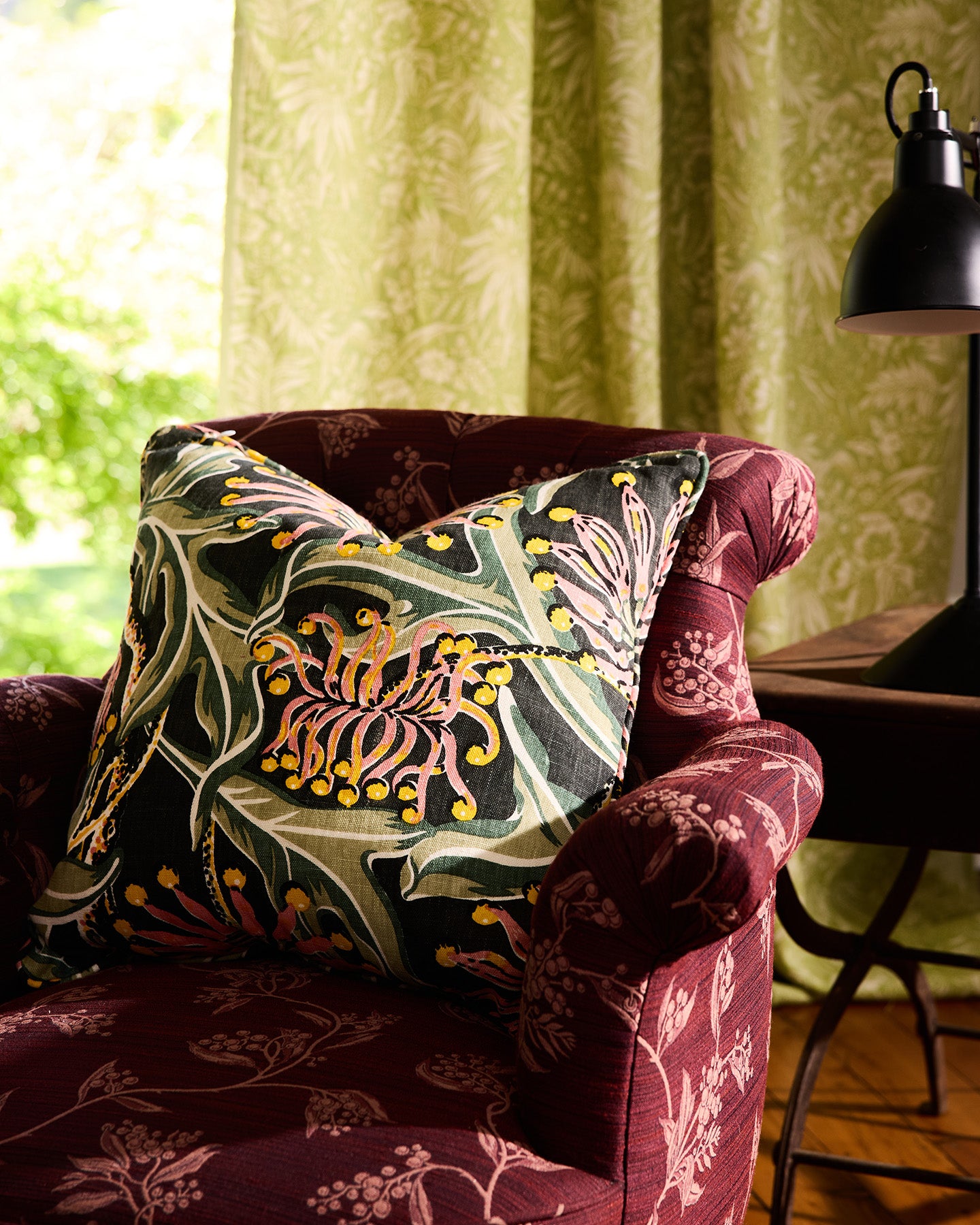 Utopia Goods Firewheel Earth Medium Cushion Cover: botanical print linen pillow on burgundy floral armchair by window