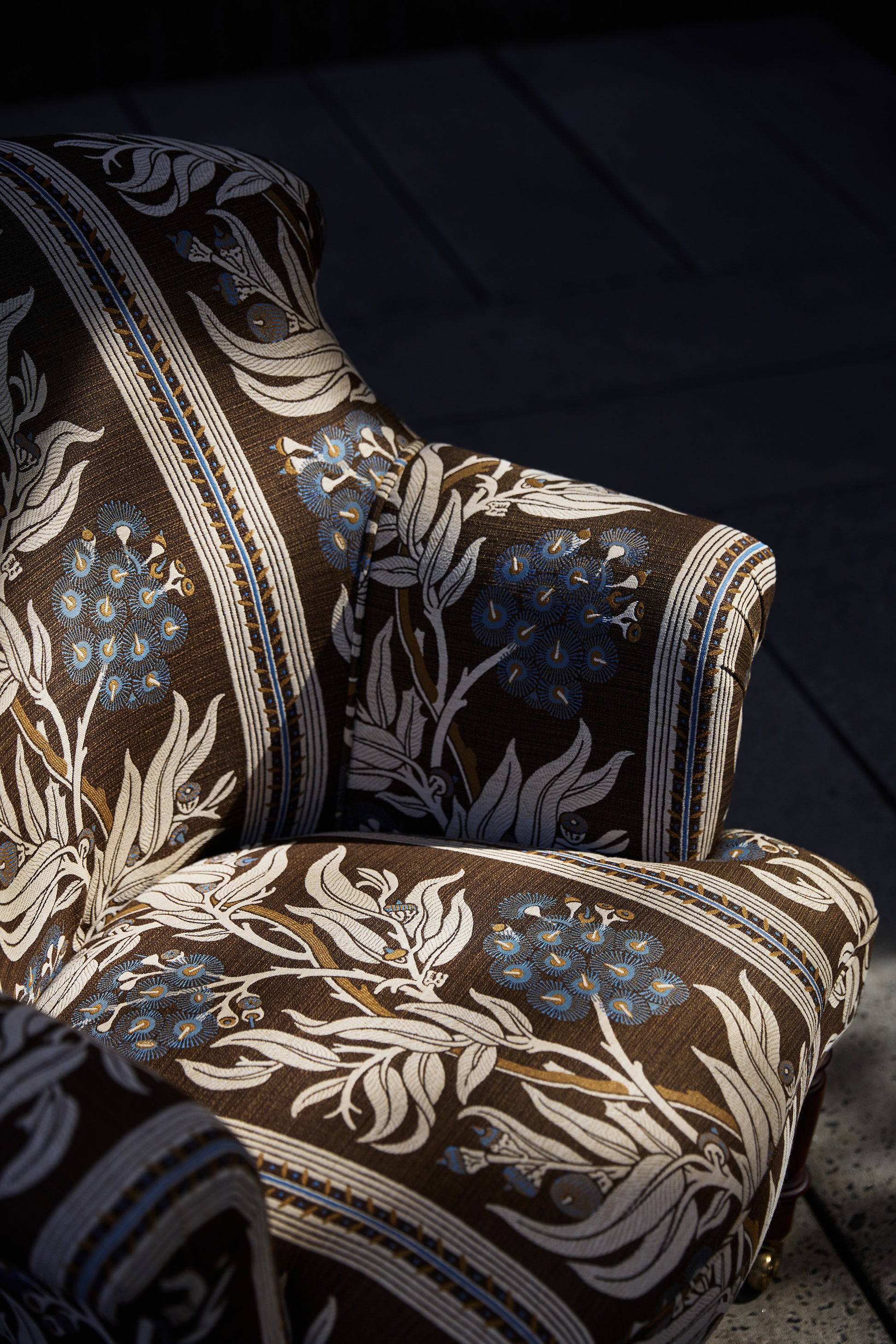 Utopia Goods: upholstered armchair with brown fabric featuring blue floral pattern and decorative striping