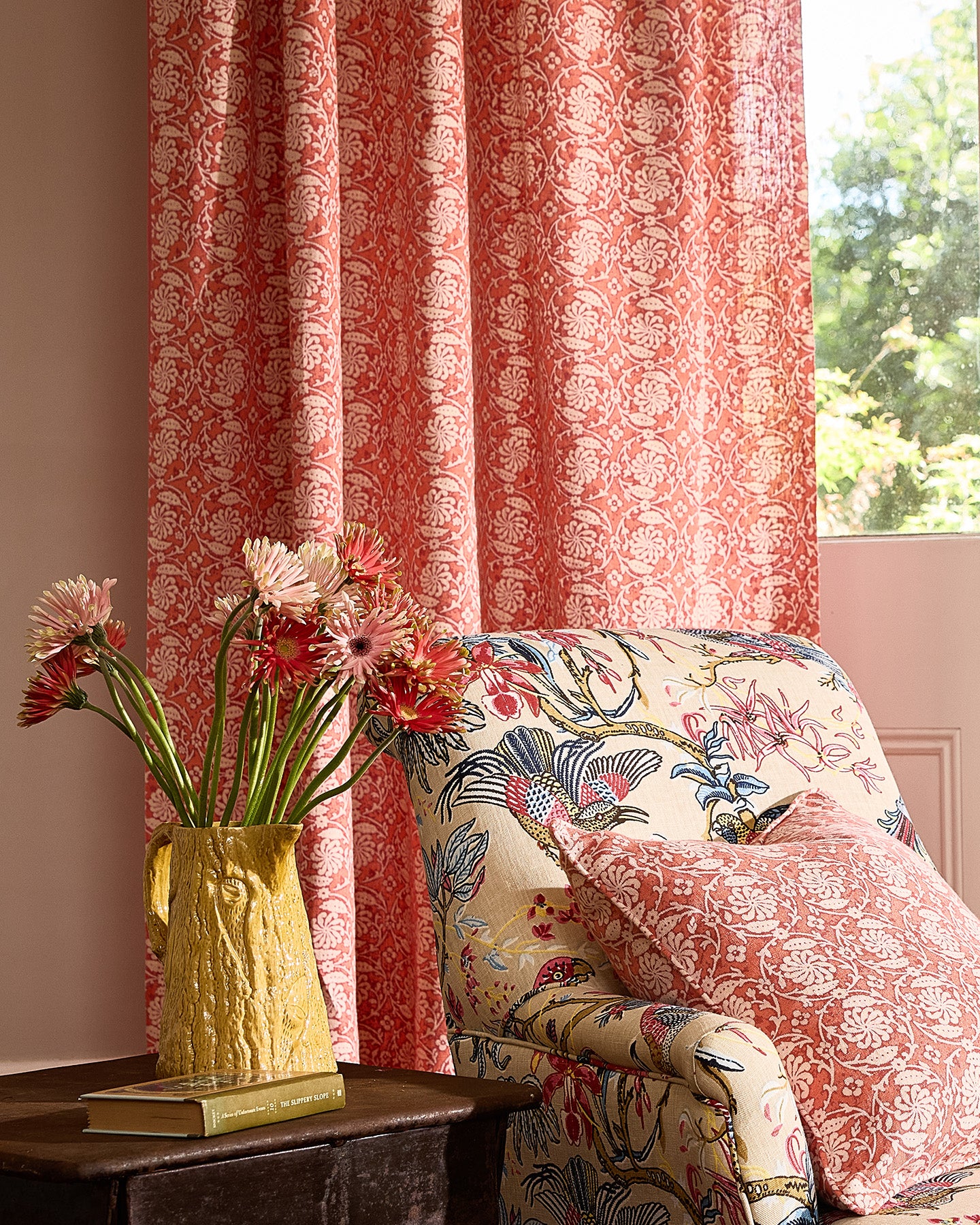 Utopia Goods Pinwheel Coral Furnishing Linen: coral red curtains with white floral pattern beside floral upholstered chair