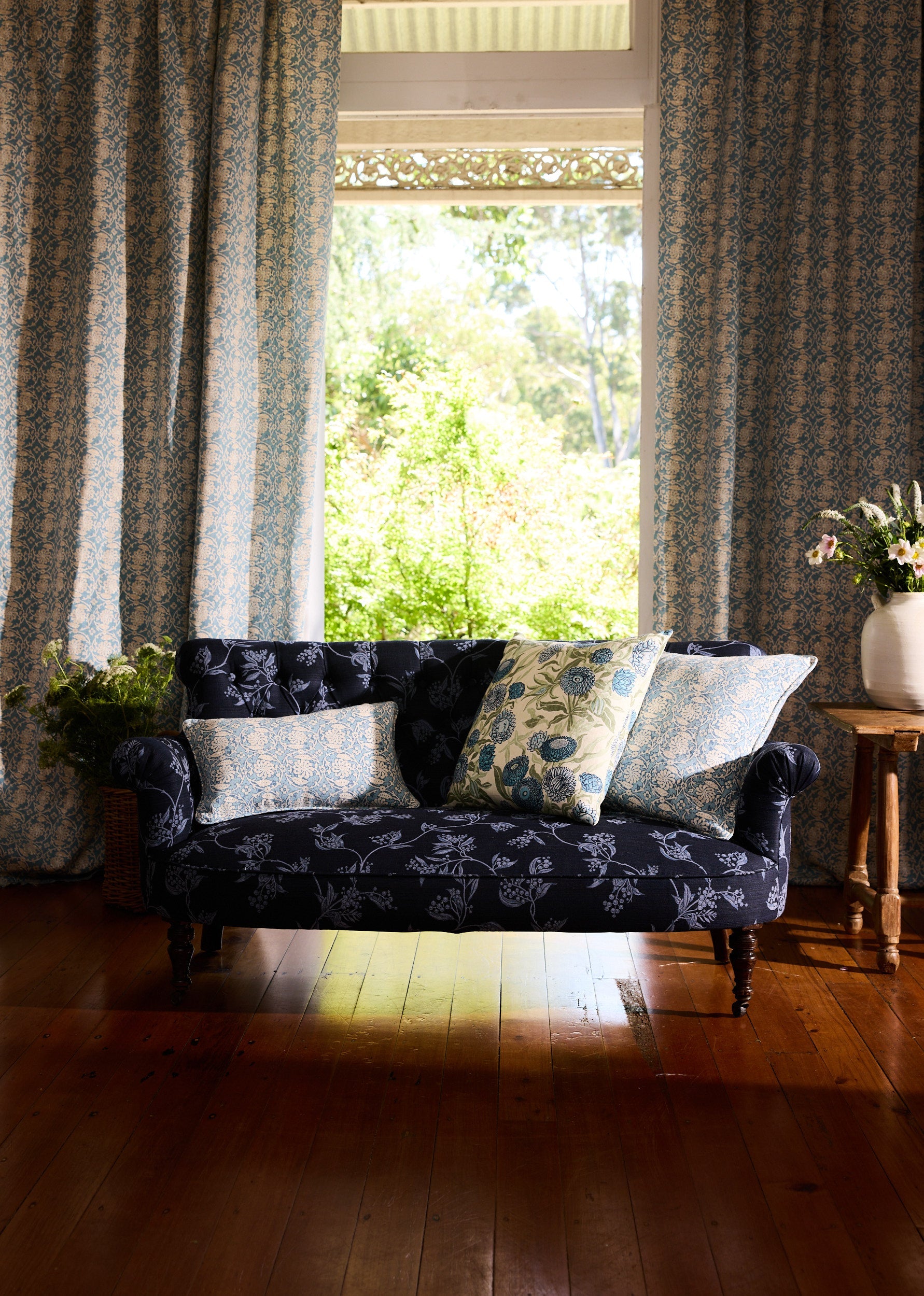Utopia Goods Pinwheel Ocean Medium Cushion Cover: blue floral patterned cushion on dark sofa with matching curtains in bright room