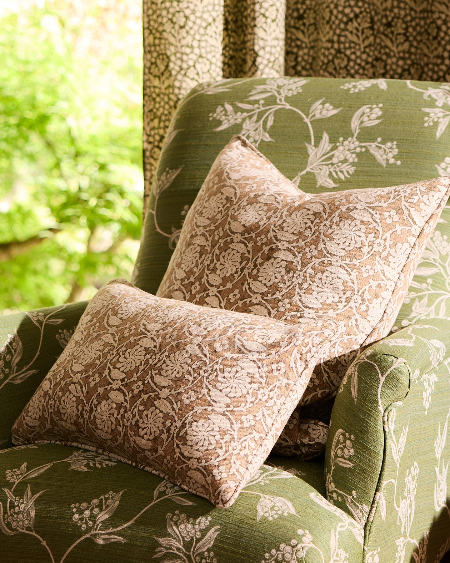 Utopia Goods Pinwheel Sepia Bolster Cushion Cover: sepia floral patterned bolster pillow on green botanical armchair