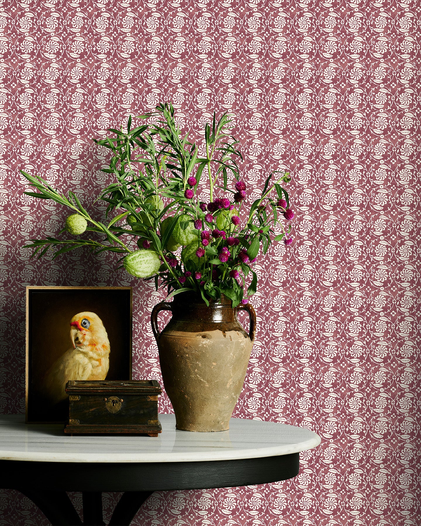 Decorative table with vase of flowers against Utopia Goods red wallpaper - Designer floral wallpaper - Pinwheel Pinot Red Wallpaper